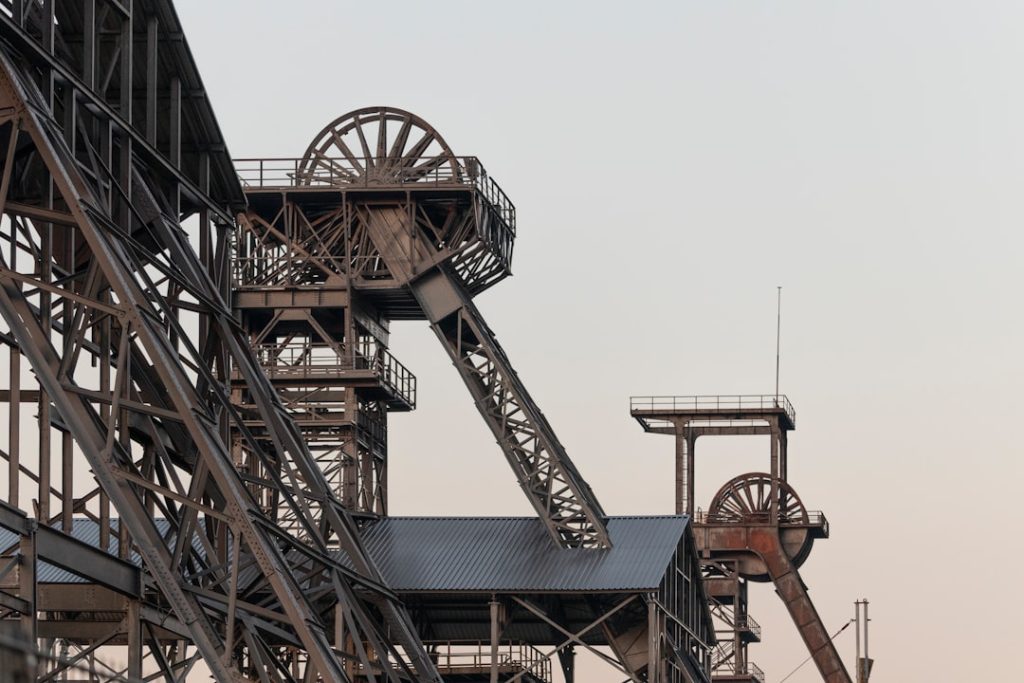 a very tall metal structure with a clock on it's side