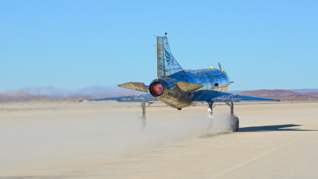 A blue and yellow airplane is on a runway