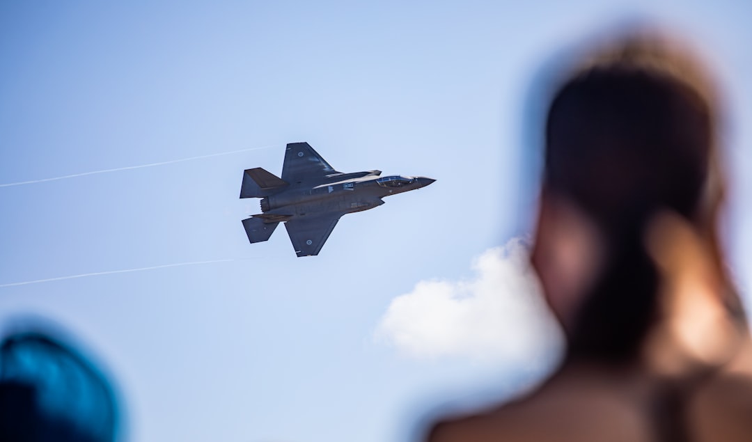 Fighter jet flying in a clear blue sky.