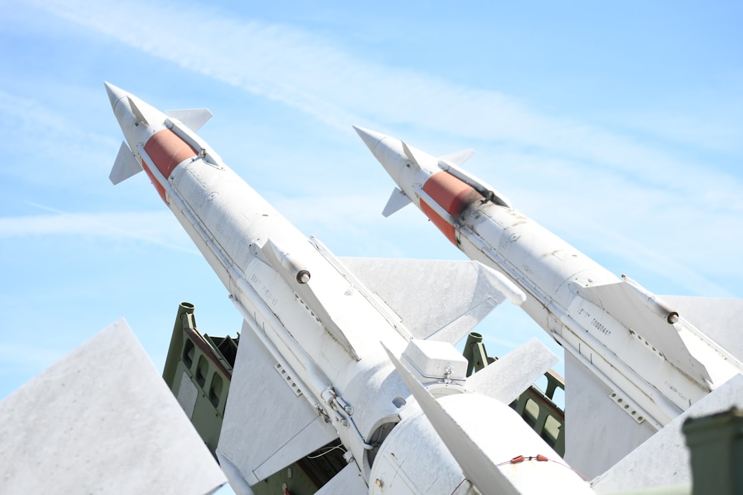 Two white missiles pointed upwards against blue sky