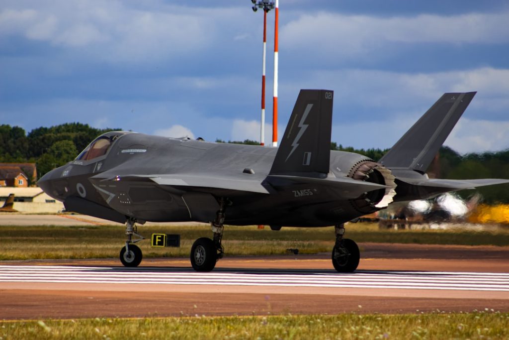 a fighter jet sitting on top of an airport runway